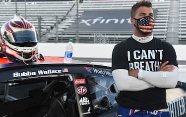 MARTINSVILLE, VIRGINIA - JUNE 10: Bubba Wallace, driver of the #43 Richard Petty Motorsports Chevrolet, wears a "I Can't Breathe - Black Lives Matter" t-shirt under his firesuit in solidarity with protesters around the world taking to the streets after the death of George Floyd on May 25, waits on the grid prior to the NASCAR Cup Series Blue-Emu Maximum Pain Relief 500 at Martinsville Speedway on June 10, 2020 in Martinsville, Virginia. (Photo by Jared C. Tilton/Getty Images)