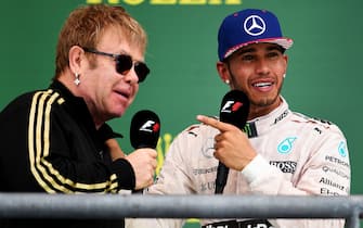 AUSTIN, TX - OCTOBER 25:  Lewis Hamilton of Great Britain and Mercedes GP celebrates on the podium with Elton John after winning the United States Formula One Grand Prix and the championship at Circuit of The Americas on October 25, 2015 in Austin, United States.  (Photo by Lars Baron/Getty Images)