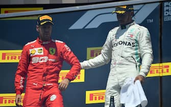 MONTREAL, QUEBEC - JUNE 09: Race winner Lewis Hamilton of Great Britain and Mercedes GP pulls second placed Sebastian Vettel of Germany and Ferrari onto the top step of the podium during the F1 Grand Prix of Canada at Circuit Gilles Villeneuve on June 09, 2019 in Montreal, Canada. (Photo by Dan Mullan/Getty Images)