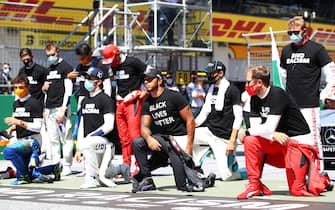 SPIELBERG, AUSTRIA - JULY 05: Lewis Hamilton of Great Britain and Mercedes GP, Pierre Gasly of France and Scuderia AlphaTauri  and some of the F1 drivers take a knee on the grid in support of the Black Lives Matter movement ahead of the Formula One Grand Prix of Austria at Red Bull Ring on July 05, 2020 in Spielberg, Austria. (Photo by Mark Thompson/Getty Images)
