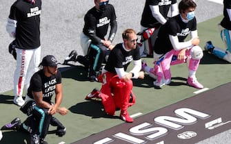 SPIELBERG, AUSTRIA - JULY 05: Sebastian Vettel of Germany and Ferrari, Lewis Hamilton of Great Britain and Mercedes GP and Lance Stroll of Canada and Racing Point take a knee in support of the 'Black Lives Matter' movement during the Formula One Grand Prix of Austria at Red Bull Ring on July 05, 2020 in Spielberg, Austria. (Photo by Peter Fox/Getty Images)