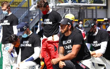 SPIELBERG, AUSTRIA - JULY 05: Lewis Hamilton of Great Britain and Mercedes GP, Pierre Gasly of France and Scuderia AlphaTauri  and some of the F1 drivers take a knee on the grid in support of the Black Lives Matter movement ahead of the Formula One Grand Prix of Austria at Red Bull Ring on July 05, 2020 in Spielberg, Austria. (Photo by Mark Thompson/Getty Images)