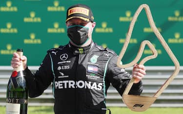 JULY 05: Valtteri Bottas, Mercedes-AMG Petronas F1, celebrates with his champagne and trophy on the podium during the Austrian GP on Sunday July 05, 2020. (Photo by Andy Hone / LAT Images)
