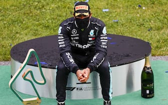 RED BULL RING, AUSTRIA - JULY 12: Race winner Lewis Hamilton, Mercedes-AMG Petronas F1 on the podium with the trophy and the champagne during the Styrian GP at Red Bull Ring on Sunday July 12, 2020 in Spielberg, Austria. (Photo by Glenn Dunbar / LAT Images)
