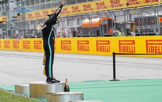 Mercedes' British driver Lewis Hamilton raises a fist on the podium after winning the Formula One Styrian Grand Prix race on July 12, 2020 in Spielberg, Austria. (Photo by LEONHARD FOEGER / POOL / AFP) (Photo by LEONHARD FOEGER/POOL/AFP via Getty Images)