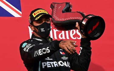 Winner Mercedes' British driver Lewis Hamilton holds his trophy as he celebrates on the podium after the Formula One Emilia Romagna Grand Prix at the Autodromo Internazionale Enzo e Dino Ferrari race track in Imola, Italy, on November 1, 2020. (Photo by MIGUEL MEDINA / POOL / AFP) (Photo by MIGUEL MEDINA/POOL/AFP via Getty Images)