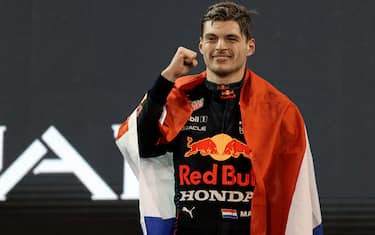 2021 FIA Formula One World Champion Red Bull's Dutch driver Max Verstappen celebrates on the podium of the Yas Marina Circuit after the Abu Dhabi Formula One Grand Prix on December 12, 2021. - Max Verstappen became the first Dutchman ever to win the Formula One world championship title when he won a dramatic season-ending Abu Dhabi Grand Prix at the Yas Marina circuit on December 12, 2021. The Red Bull driver won his 10th race of the season to finish ahead of seven-time champion Lewis Hamilton. (Photo by KAMRAN JEBREILI / POOL / AFP) (Photo by KAMRAN JEBREILI/POOL/AFP via Getty Images)