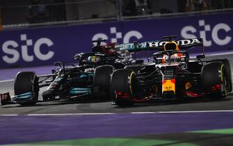JEDDAH STREET CIRCUIT, SAUDI ARABIA - DECEMBER 05: Max Verstappen, Red Bull Racing RB16B, and Sir Lewis Hamilton, Mercedes W12, make contact as they battle for the lead during the Saudi Arabia GP  at Jeddah Street Circuit on Sunday December 05, 2021 in Jeddah, Saudi Arabia. (Photo by Andy Hone / LAT Images)
