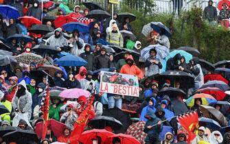 AUTODROMO INTERNAZIONALE ENZO E DINO FERRARI, ITALY - APRIL 24: Fans protect themselves from the rain in a grandstand during the Emilia Romagna GP at Autodromo Internazionale Enzo e Dino Ferrari on Sunday April 24, 2022 in imola, Italy. (Photo by Mark Sutton / Sutton Images)