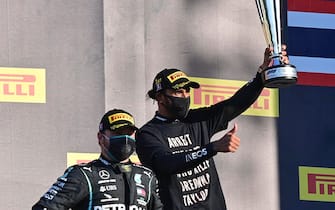 epa08666750 The winner British Formula One driver Lewis Hamilton of Mercedes-AMG Petronas (R) and second placed Finnish Formula One driver Valtteri Bottas of Mercedes-AMG Petronas celebrate on the podium after the Formula One Grand Prix of Tuscany at the race track in Mugello, Italy 13 September 2020.  EPA/Miguel Medina / Pool