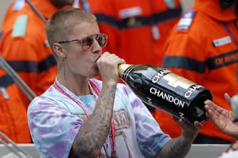 epa05336129 Canadian singer Justin Bieber drinks champagne after British Formula One driver Lewis Hamilton of Mercedes AMG GP won the Monaco Formula One Grand Prix at the Monte Carlo circuit in Monaco, 29 May 2016.  EPA/YOAN VALAT