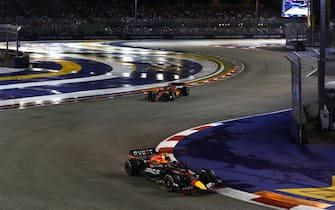 MARINA BAY STREET CIRCUIT, SINGAPORE - OCTOBER 02: Sergio Perez, Red Bull Racing RB18, leads Charles Leclerc, Ferrari F1-75 during the Singapore GP at Marina Bay Street Circuit on Sunday October 02, 2022 in Singapore, Singapore. (Photo by Zak Mauger / LAT Images)