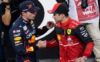 YAS MARINA CIRCUIT, UNITED ARAB EMIRATES - NOVEMBER 19: Pole man Max Verstappen, Red Bull Racing, and Charles Leclerc, Ferrari, congratulate each other after Qualifying during the Abu Dhabi GP at Yas Marina Circuit on Saturday November 19, 2022 in Abu Dhabi, United Arab Emirates. (Photo by Simon Galloway / LAT Images)