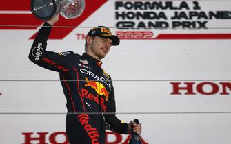 SUZUKA, JAPAN - OCTOBER 09: Max Verstappen, Red Bull Racing, 1st position, leaves the podium with his trophy and Champagne during the Japanese GP at Suzuka on Sunday October 09, 2022 in Suzuka, Japan. (Photo by Andy Hone / LAT Images)