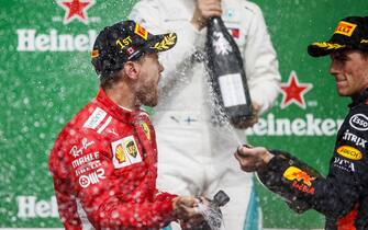 CIRCUIT GILLES-VILLENEUVE, CANADA - JUNE 10: Valtteri Bottas, Mercedes AMG F1, 2nd position, Sebastian Vettel, Ferrari, 1st position, and Max Verstappen, Red Bull Racing, 3rd position, celebrate with Champagne on the podium during the Canadian GP at Circuit Gilles-Villeneuve on June 10, 2018 in Circuit Gilles-Villeneuve, Canada. (Photo by Zak Mauger / LAT Images)