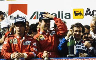 IMOLA, ITALY - MAY 01: Patrick Tambay, 1st position, celebrates on the podium with Alain Prost, 2nd position, and RenÃ© Arnoux, 3rd position during the San Marino GP at Imola on May 01, 1983 in Imola, Italy. (Photo by LAT Images)