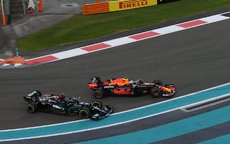 YAS MARINA CIRCUIT, UNITED ARAB EMIRATES - DECEMBER 12: Max Verstappen, Red Bull Racing RB16B, battles with Sir Lewis Hamilton, Mercedes W12, on the opening lap during the Abu Dhabi GP at Yas Marina Circuit on Sunday December 12, 2021 in Abu Dhabi, United Arab Emirates. (Photo by Simon Galloway / LAT Images)