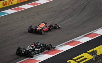 YAS MARINA CIRCUIT, UNITED ARAB EMIRATES - DECEMBER 12: Max Verstappen, Red Bull Racing RB16B, passes Sir Lewis Hamilton, Mercedes W12, for the lead on the final lap during the Abu Dhabi GP at Yas Marina Circuit on Sunday December 12, 2021 in Abu Dhabi, United Arab Emirates. (Photo by Simon Galloway / LAT Images)