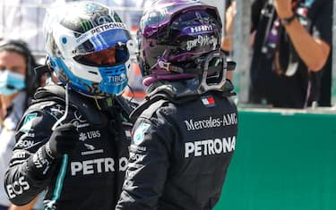 Mercedes' British driver Lewis Hamilton (R) congratulates Mercedes' Finnish driver Valtteri Bottas after the qualifying round at the Austrian Formula One Grand Prix on July 4, 2020 in Spielberg, Austria. - Seven months after they last competed in earnest, the Formula One circus will push a post-lockdown  re-set  button to open the 2020 season in Austria on July 5. (Photo by LEONHARD FOEGER / AFP)
