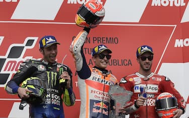 TOPSHOT - Winner Honda's Spanish biker Marc Marquez (C), runner-up Yamaha's Italian Valentino Rossi (L) and third-place Ducati's Italian Andrea Dovizioso pose on the podium of the MotoGP Argentina Grand Prix at the Termas de Rio Hondo circuit in Santiago del Estero, Argentina, on March 31, 2019. (Photo by Juan MABROMATA / AFP)        (Photo credit should read JUAN MABROMATA/AFP via Getty Images)