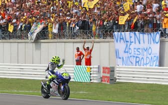 Italian rider Valentino Rossi waves to the crowd after fan after pulling out of the race, having dropped a lap behind the frontrunners when he slid off the circuit on the fifth lap, 02 September 2007 at the San Marino Moto Grand Prix in Misano Adriatico.   Australian rider Casey Stoner took another stride towards his first world championship title by outclassing the field to claim his third consecutive Moto GP victory    AFP PHOTO /  MARIO LAPORTA  (Photo credit should read MARIO LAPORTA/AFP via Getty Images)