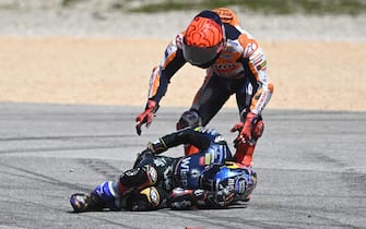 Honda Spanish rider Marc Marquez (R) checks on Aprilia Portuguese rider Miguel Oliveira after crashing during the MotoGP race of the Portuguese Grand Prix at the Algarve International Circuit in Portimao, on March 26, 2023. (Photo by PATRICIA DE MELO MOREIRA / AFP) (Photo by PATRICIA DE MELO MOREIRA/AFP via Getty Images)