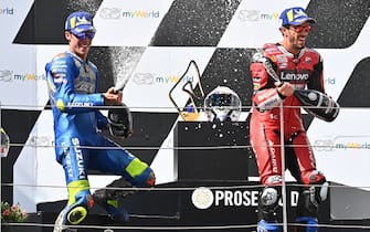Ducati's Italian rider Andrea Dovizioso (R) and second placed Suzuki Ecstar's Spanish rider Joan Mir celebrate with champagne on the podium of the Moto GP Austrian Grand Prix at the Red Bull Ring circuit in Spielberg, Austria on August 16, 2020. (Photo by Joe Klamar / AFP) (Photo by JOE KLAMAR/AFP via Getty Images)