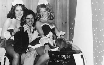 British motorbike champion Barry Sheene (1950 - 2003) astride a Penthouse-sponsored BMW at the Racing and Sporting Motorcycle Show at the Royal Agricultural Hall, Westminster, 3rd January 1975. Adding a touch of glamour are Penthouse Pets Emma Bryant (left) and Jill Kemp. (Photo by J. Wilds/Keystone/Hulton Archive/Getty Images)