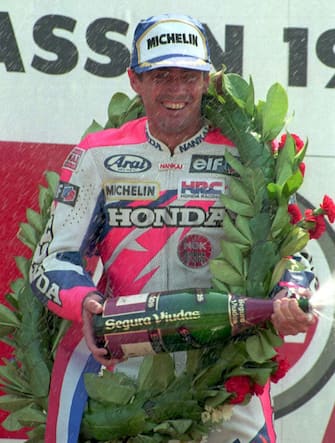 25 JUN 1994:  MICK DOOHAN OF AUSTRALIA LAUGHS AS HE IS SHOWERED WITH CHAMPAGNE ON THE PODIUM AND WEARS THE WINNERS WREATH AROUND HIS NECK AFTER WINNING THE DUTCH 500CC MOTORBIKE GRAND PRIX AT ASSEN, AND EXTENDING HIS LEAD IN THE WORLD CHAMPIONSHIP POINTS. Mandatory Credit: Mike Cooper/ALLSPORT