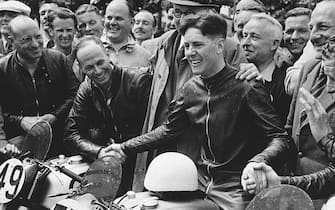 British motorcyclist Geoff Duke is congratulated by his opponents after winning the Senior Tourists Trophy Race on the Isle of Man. His average race speed was 92.27 m.p.h. Other members of the winning Norton team pictured are 40 year old Harold Daniell (left, wearing glasses), a triple winner of the event; John Lockett (shaking Duke's hand) who came third and Artie Bell (far right) who was a close second. (Photo by © Hulton-Deutsch Collection/CORBIS/Corbis via Getty Images)