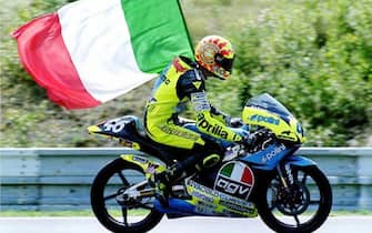 Valentino Rossi festeggia la sua vittoria nella categoria 125 cc sventolando la bandiera italiana al termine della gara a Brno, in una immagine del 18 agosto 1996. ANSA/IGOR ZEHL