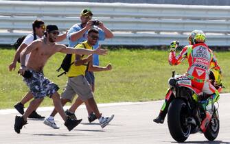 Il pilota Valentino Rossi in pista con un gruppo di suoi fans dopo il secondo posto nella gara della MotoGP nel circuito di Misano Adriatico, 16 settembre 2012. ANSA/ PASQUALE BOVE