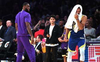 LOS ANGELES, CALIFORNIA - OCTOBER 14:  LeBron James #23 of the Los Angeles Lakers and Stephen Curry #30 of the Golden State Warriors laugh on the sidelines during a timeout in a 104-98 Lakers preseason win at Staples Center on October 14, 2019 in Los Angeles, California. (Photo by Harry How/Getty Images)