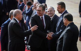 1174210898 Serbian President Aleksandar Vucic (C) shakes hands with former NBA basketball player Hidayet Turkoglu (R) as he speaks with his Turkish counterpart Recep Tayyip Erdogan (L) prior to their meeting in Belgrade on October 7, 2019. (Photo by OLIVER BUNIC / AFP) (Photo by OLIVER BUNIC/AFP via Getty Images)