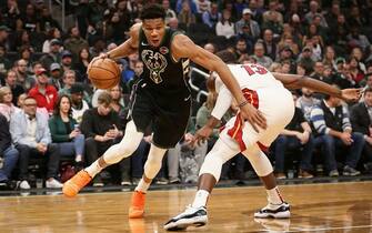 1137695251 MILWAUKEE, WISCONSIN - MARCH 22: Giannis Antetokounmpo #34 of the Milwaukee Bucks dribbles the ball while being guarded by Bam Adebayo #13 of the Miami Heat in the first quarter at the Fiserv Forum on March 22, 2019 in Milwaukee, Wisconsin. NOTE TO USER: User expressly acknowledges and agrees that, by downloading and or using this photograph, User is consenting to the terms and conditions of the Getty Images License Agreement. (Photo by Dylan Buell/Getty Images)