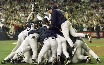 SAN DIEGO, :  Members of the New York Yankees pile on each other after winning game four of the World Series against the San Diego Padres 21 October at Qualcomm Stadium in San Diego, CA.  The Yankees won the game 3-0 to sweep the series from the Padres. (ELECTRONIC IMAGE)   AFP PHOTO/JEFF HAYNES (Photo credit should read JEFF HAYNES/AFP via Getty Images)