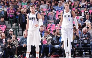 DALLAS, TX - OCTOBER 11: Luka Doncic #77, and Kristaps Porzingis #6 of the Dallas Mavericks looks on against the Milwaukee Bucks during a pre-season game on October 11, 2019 at the American Airlines Center in Dallas, Texas. NOTE TO USER: User expressly acknowledges and agrees that, by downloading and or using this photograph, User is consenting to the terms and conditions of the Getty Images License Agreement. Mandatory Copyright Notice: Copyright 2019 NBAE (Photo by Glenn James/NBAE via Getty Images)