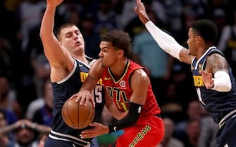 DENVER, COLORADO - NOVEMBER 12: Trae Young #11 of the Atlanta Hawks drives against Nikola Jokic #15 and Gary harris #14 of the Denver Nuggets in the fourth quarter at the Pepsi Center on November 12, 2019 in Denver, Colorado.  NOTE TO USER: User expressly acknowledges and agrees that, by downloading and or using this photograph, User is consenting to the terms and conditions of the Getty Images License Agreement. (Photo by Matthew Stockman/Getty Images)