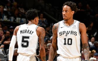 SAN ANTONIO, TX - OCTOBER 23: Dejounte Murray #5 and DeMar DeRozan #10 of the San Antonio Spurs walk on the court during the game against the New York Knicks on October 23, 2019 at the AT&T Center in San Antonio, Texas. NOTE TO USER: User expressly acknowledges and agrees that, by downloading and or using this photograph, user is consenting to the terms and conditions of the Getty Images License Agreement. Mandatory Copyright Notice: Copyright 2019 NBAE (Photos by Logan Riely/NBAE via Getty Images)
