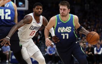 DALLAS, TEXAS - NOVEMBER 26:  Luka Doncic #77 of the Dallas Mavericks dribbles the ball against Paul George #13 of the Los Angeles Clippers at American Airlines Center on November 26, 2019 in Dallas, Texas.  NOTE TO USER: User expressly acknowledges and agrees that, by downloading and or using this photograph, User is consenting to the terms and conditions of the Getty Images License Agreement.  (Photo by Ronald Martinez/Getty Images)