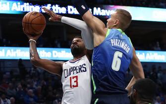 DALLAS, TEXAS - NOVEMBER 26:  Paul George #13 of the Los Angeles Clippers takes a shot against Kristaps Porzingis #6 of the Dallas Mavericks at American Airlines Center on November 26, 2019 in Dallas, Texas.  NOTE TO USER: User expressly acknowledges and agrees that, by downloading and or using this photograph, User is consenting to the terms and conditions of the Getty Images License Agreement.  (Photo by Ronald Martinez/Getty Images)