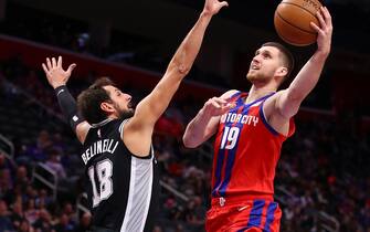 DETROIT, MICHIGAN - DECEMBER 01: Sviatoslav Mykhailiuk #19 of the Detroit Pistons drives to the basket against Marco Belinelli #18 of the San Antonio Spurs during the first half at Little Caesars Arena on December 01, 2019 in Detroit, Michigan. NOTE TO USER: User expressly acknowledges and agrees that, by downloading and or using this photograph, User is consenting to the terms and conditions of the Getty Images License Agreement. (Photo by Gregory Shamus/Getty Images)
