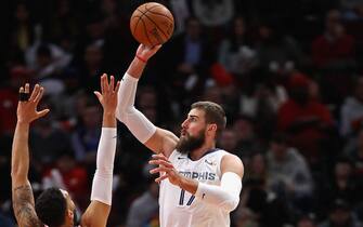 1191995445 CHICAGO, ILLINOIS - DECEMBER 04: Jonas Valanciunas #17 of the Memphis Grizzlies shoots between Denzel Valentine #45 and Daniel Gafford #12 of the Chicago Bulls at the United Center on December 04, 2019 in Chicago, Illinois. NOTE TO USER: User expressly acknowledges and agrees that , by downloading and or using this photograph, User is consenting to the terms and conditions of the Getty Images License Agreement. (Photo by Jonathan Daniel/Getty Images)