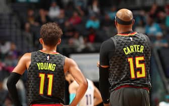 CHARLOTTE, NC - DECEMBER 8: Trae Young #11 of the Atlanta Hawks and Vince Carter #15 of the Atlanta Hawks looks on against the Charlotte Hornets on December 8, 2019 at Spectrum Center in Charlotte, North Carolina. NOTE TO USER: User expressly acknowledges and agrees that, by downloading and or using this photograph, User is consenting to the terms and conditions of the Getty Images License Agreement.  Mandatory Copyright Notice: Copyright 2019 NBAE (Photo by Brock Williams-Smith/NBAE via Getty Images) 
