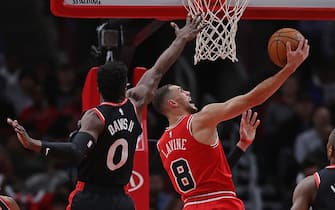 CHICAGO, ILLINOIS - DECEMBER 09: Zach LaVine #8 of the Chicago Bulls lays in a shot past Terence Davis #0 of the Toronto Raptors
 at the United Center on December 09, 2019 in Chicago, Illinois. NOTE TO USER: User expressly acknowledges and agrees that , by downloading and or using this photograph, User is consenting to the terms and conditions of the Getty Images License Agreement. (Photo by Jonathan Daniel/Getty Images)