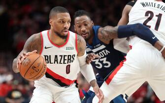 PORTLAND, OREGON - DECEMBER 21: Damian Lillard #0 of the Portland Trail Blazers dribbles with the ball alongside Robert Covington #33 of the Minnesota Timberwolves in the second quarter during their game at Moda Center on December 21, 2019 in Portland, Oregon. NOTE TO USER: User expressly acknowledges and agrees that, by downloading and or using this photograph, User is consenting to the terms and conditions of the Getty Images License Agreement (Photo by Abbie Parr/Getty Images) (Photo by Abbie Parr/Getty Images)