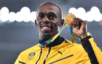 Jamaica's Usain Bolt holds his gold medal during the podium ceremony for the Men's 200m during the athletics event at the Rio 2016 Olympic Games at the Olympic Stadium in Rio de Janeiro on August 19, 2016.   / AFP / FABRICE COFFRINI        (Photo credit should read FABRICE COFFRINI/AFP via Getty Images)