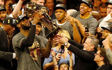 TOPSHOT - Cleveland Cavaliers forward LeBron James hoists the Larry O'Brien trophy after defeating the Golden State Warriors to win the NBA Finals on June 19, 2016 in Oakland, California.
Powered by an amazing effort from LeBron James, the Cleveland Cavaliers completed the greatest comeback in NBA Finals history, dethroning defending champion Golden State 93-89 to capture their first NBA title. The Cavaliers won the best-of-seven series 4-3 to claim the first league crown in their 46-season history and deliver the first major sports champion to Cleveland since the 1964 NFL Browns, ending the longest such title drought for any American city.
 / AFP / Beck Diefenbach        (Photo credit should read BECK DIEFENBACH/AFP via Getty Images)
