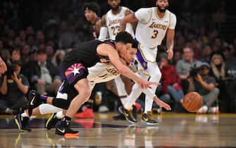 1191217101 LOS ANGELES, CA - JANUARY 01: Devin Booker #1 of the Phoenix Suns and Danny Green #14 of the Los Angeles Lakers battle for the ball in the first half at Staples Center on January 1, 2020 in Los Angeles, California. NOTE TO USER: User expressly acknowledges and agrees that, by downloading and/or using this photograph, user is consenting to the terms and conditions of the Getty Images License Agreement. (Photo by John McCoy/Getty Images)