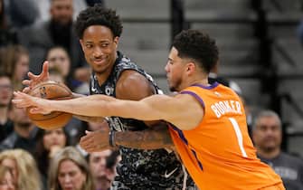 1195923582 SAN ANTONIO, TX - JANUARY 24: DeMar DeRozan #10 of the San Antonio Spurs looks for room around Devin Booker #1 of the Phoenix Sunsduring an NBA game at the AT&T Center on January 24, 2020 in San Antonio, Texas. NOTE TO USER: User expressly acknowledges and agrees that, by downloading and or using this photograph, User is consenting to the terms and conditions of the Getty Images License Agreement. (Photo by Edward A. Ornelas/Getty Images)